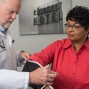 A male doctor wraps a blood pressure cuff around a woman's arm in a doctor's office