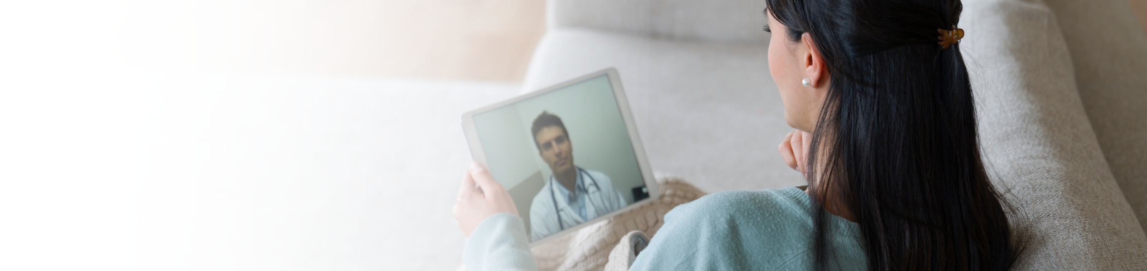 Women on tablet talking to doctor virtually